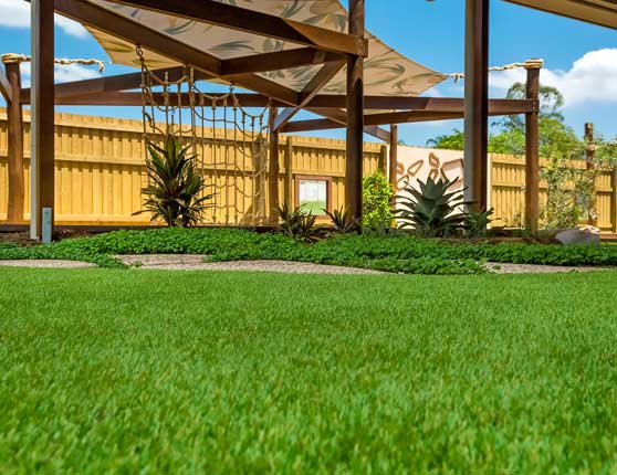 image of child care synthetic grass with shade sails in background
